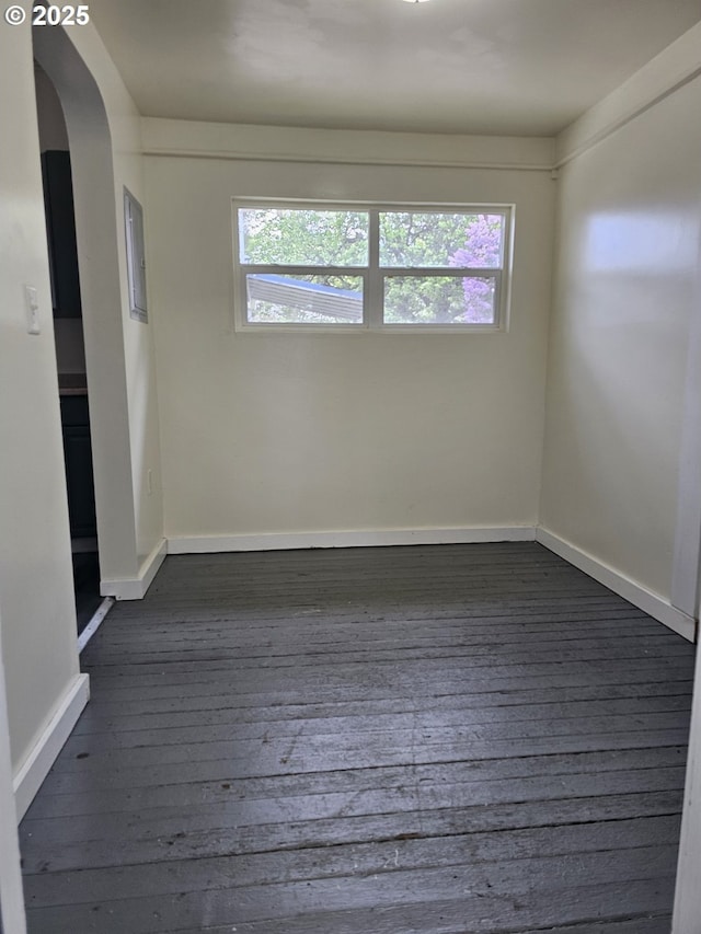 617 SW 3rd St, Pendleton, OR 97801 - spare room featuring dark wood-type flooring, arched walkways, plenty of natural light, and baseboards