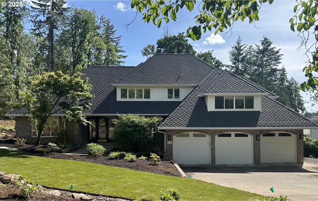 6230 SW Patton Rd, Portland, OR 97221 - view of front of home with asphalt driveway, a front lawn, brick siding, a shingled roof, and a garage