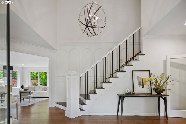 6230 SW Patton Rd, Portland, OR 97221 - stairway featuring wood finished floors, a high ceiling, crown molding, and a chandelier