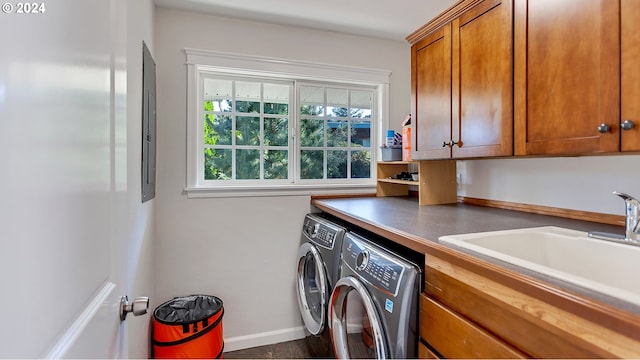 laundry room featuring baseboards, a sink, cabinet space, and independent washer and dryer