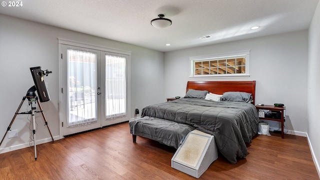 bedroom with access to outside, visible vents, french doors, and wood finished floors