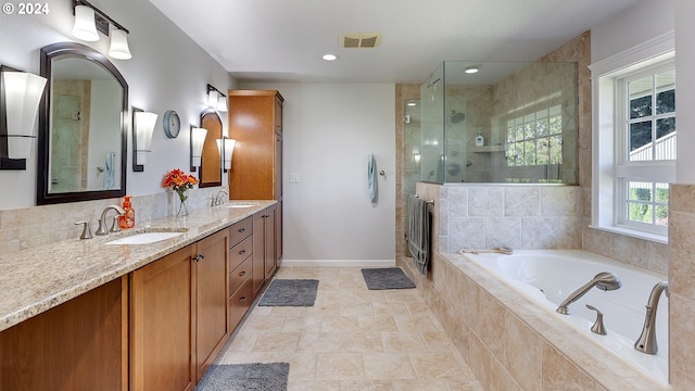 bathroom with a sink, a garden tub, and a stall shower