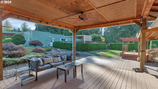 wooden deck with a yard, ceiling fan, a fenced backyard, and an outdoor hangout area