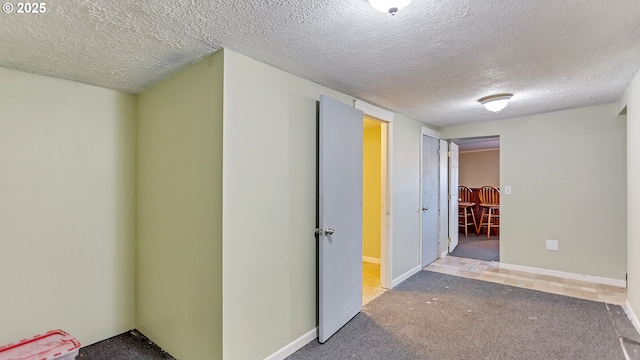 interior space featuring carpet flooring and a textured ceiling