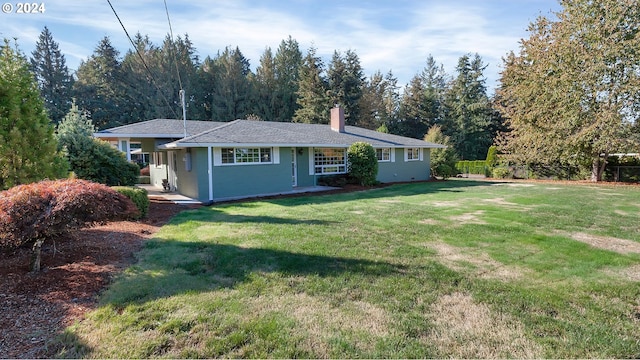 ranch-style house featuring fence, a chimney, and a front lawn