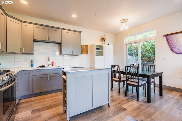 2904 SE 87th Ave, Portland, OR 97266 - kitchen featuring stainless steel stove, gray cabinets, a sink, light countertops, and backsplash