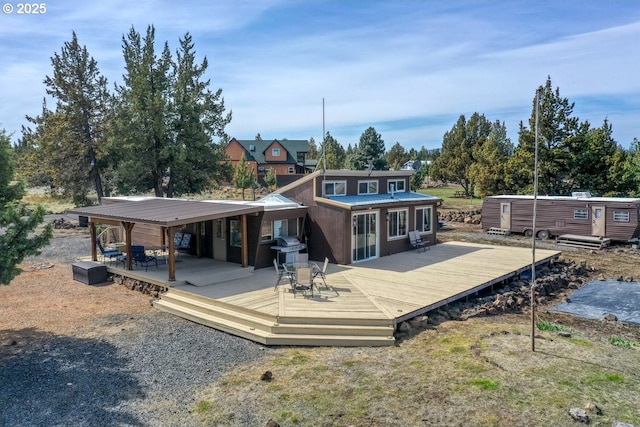rear view of property with metal roof and a wooden deck
