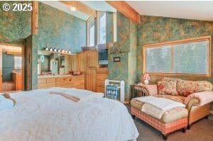 bedroom with lofted ceiling with beams and multiple windows