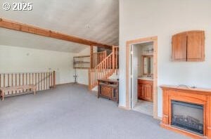 additional living space with stairs, lofted ceiling, carpet flooring, and a fireplace