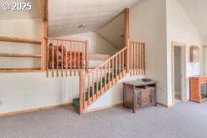 staircase with lofted ceiling and carpet flooring