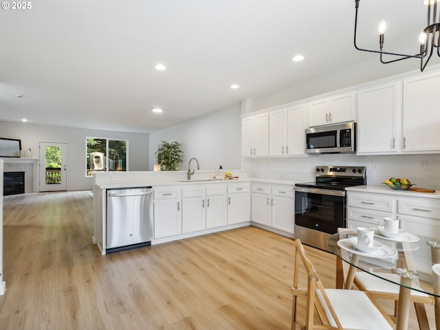 7804 SW Brookline Ln, Portland, OR 97224 - kitchen featuring stainless steel appliances, white cabinetry, light wood finished floors, recessed lighting, and light countertops
