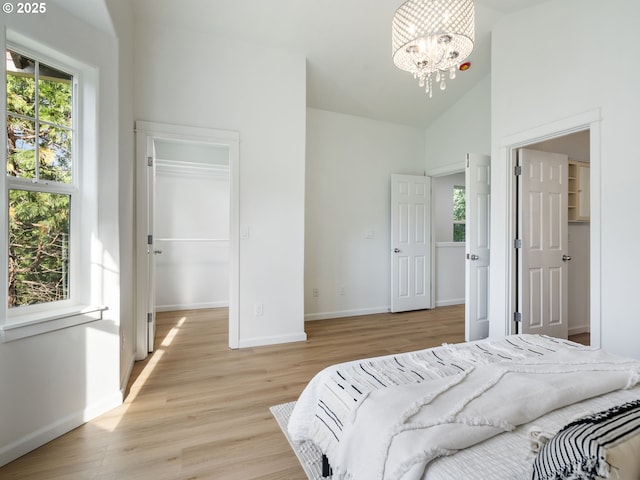 7804 SW Brookline Ln, Portland, OR 97224 - bedroom with a spacious closet, a chandelier, light wood-style flooring, vaulted ceiling, and a closet
