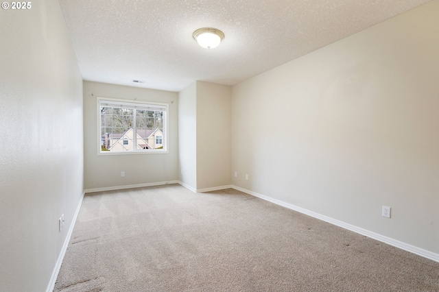 empty room featuring light carpet and a textured ceiling