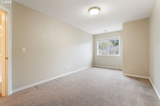 carpeted empty room with a textured ceiling