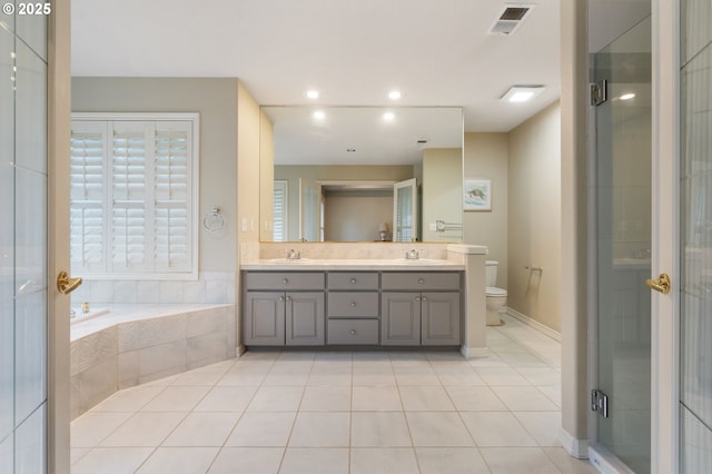 full bathroom featuring vanity, shower with separate bathtub, toilet, and tile patterned floors