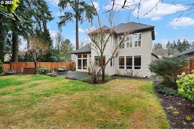 rear view of house with a patio and a lawn