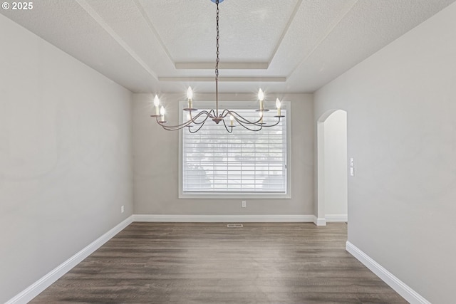 6609 Palomino Cir, West Linn, OR 97068 - unfurnished dining area with a chandelier, arched walkways, dark wood-style floors, a tray ceiling, and a textured ceiling