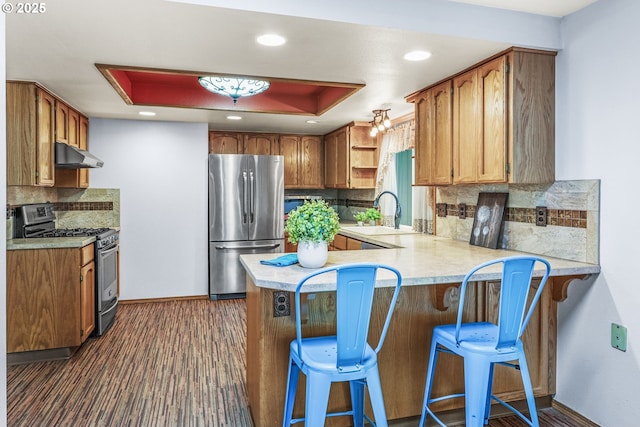 15711 NE 27th Cir, Vancouver, WA 98684 - kitchen featuring appliances with stainless steel finishes, under cabinet range hood, a peninsula, a sink, and baseboards