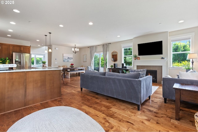 29250 SW Costa Cir E, Wilsonville, OR 97070 - living area with a chandelier, recessed lighting, a fireplace, and light wood-type flooring