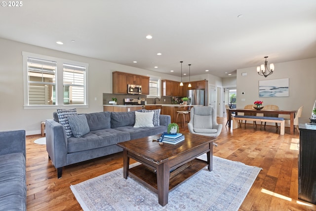 29250 SW Costa Cir E, Wilsonville, OR 97070 - living room featuring a chandelier, recessed lighting, light wood-style floors, and baseboards