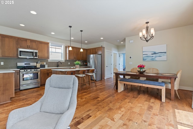 29250 SW Costa Cir E, Wilsonville, OR 97070 - kitchen with appliances with stainless steel finishes, light countertops, brown cabinetry, a chandelier, and recessed lighting