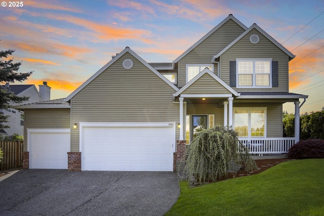 traditional-style home featuring brick siding, a garage, aphalt driveway, a porch, and a yard