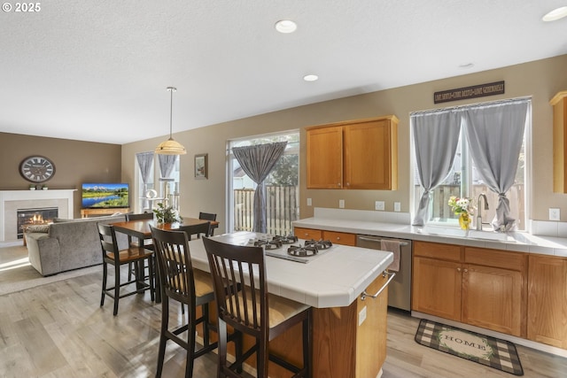 kitchen featuring white gas cooktop, tile counters, light wood-style flooring, and dishwasher