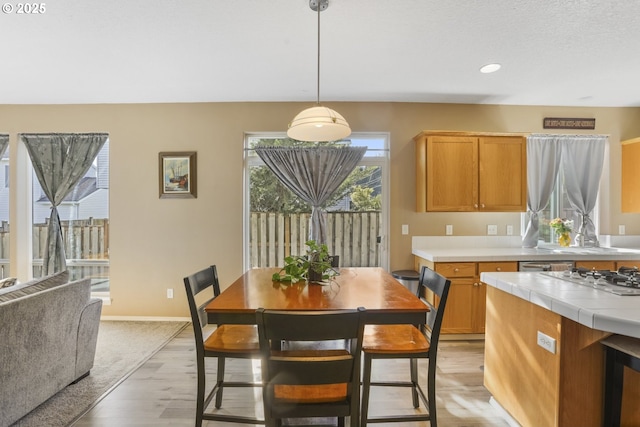 dining area featuring recessed lighting, baseboards, light wood finished floors, and beverage cooler
