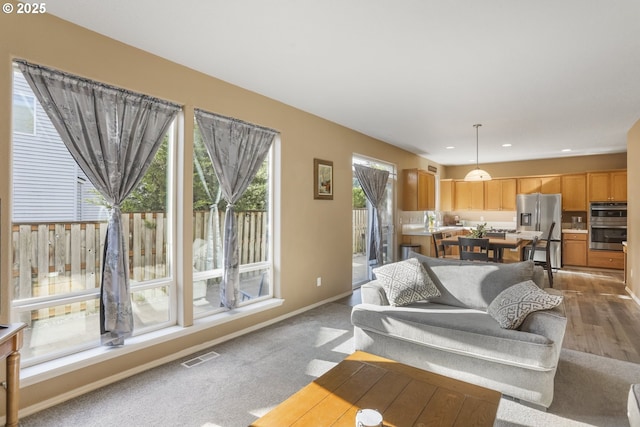 living room with baseboards, recessed lighting, and visible vents