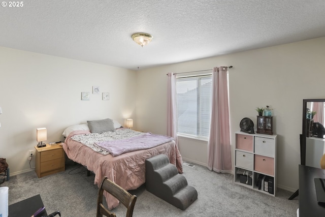 carpeted bedroom featuring baseboards, a textured ceiling, and visible vents