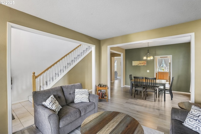 living area with baseboards, wood finished floors, and stairway