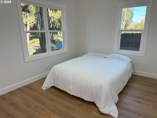 bedroom featuring wood finished floors and baseboards