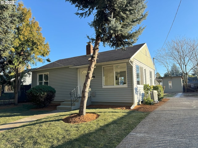 view of front of house with a chimney, a front yard, cooling unit, and fence