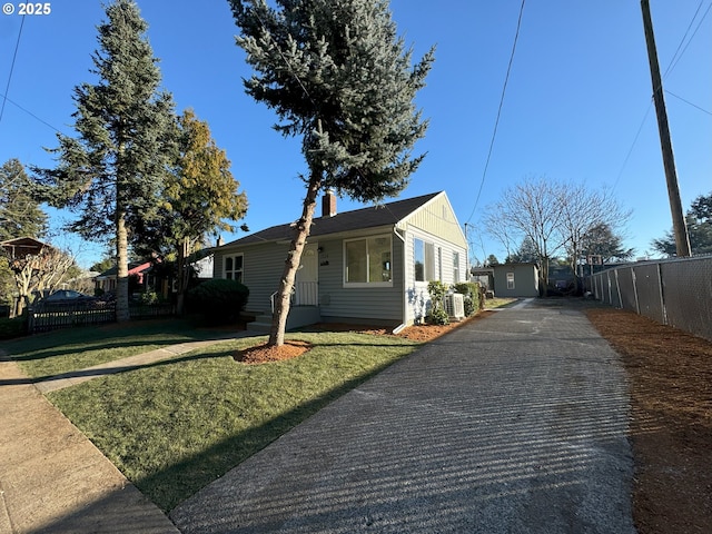 view of side of home with a yard, a chimney, fence, and central air condition unit