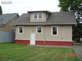 rear view of house featuring a yard