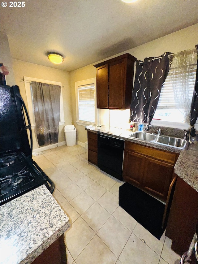 kitchen featuring light tile patterned floors, sink, dark brown cabinetry, and black dishwasher