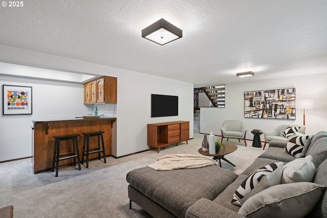 2845 SW Raleighview Dr, Portland, OR 97225 - living area featuring stairway, bar with sink, light colored carpet, a textured ceiling, and baseboards