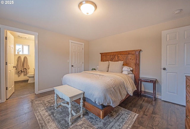 bedroom with dark wood-style flooring, visible vents, baseboards, and ensuite bath