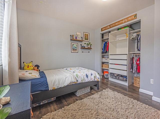 bedroom featuring wood finished floors, a closet, and baseboards