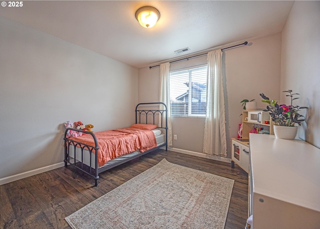 bedroom with dark wood-type flooring, visible vents, and baseboards