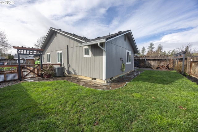 rear view of property featuring cooling unit, a fenced backyard, and a lawn