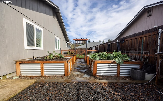 view of property exterior featuring fence private yard and a vegetable garden
