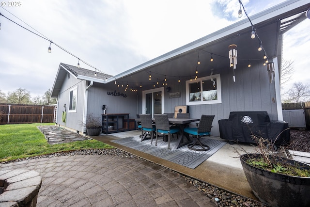 back of house with a yard, outdoor dining space, fence, and a patio