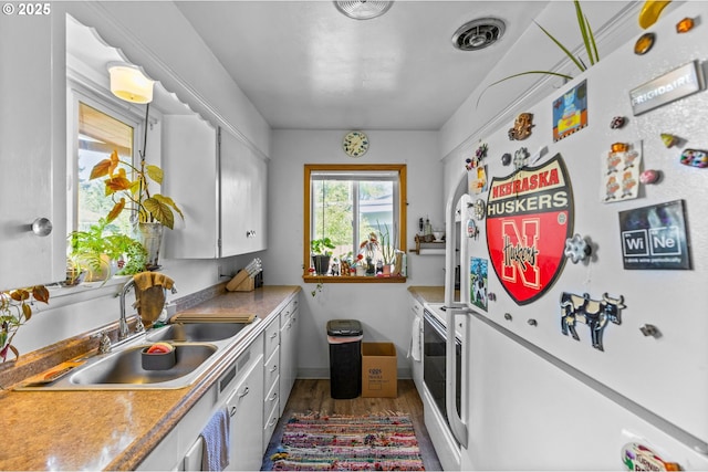520 NW 10th St, Corvallis, OR 97330 - kitchen featuring fridge, wood finished floors, a sink, white cabinets, and washer and clothes dryer