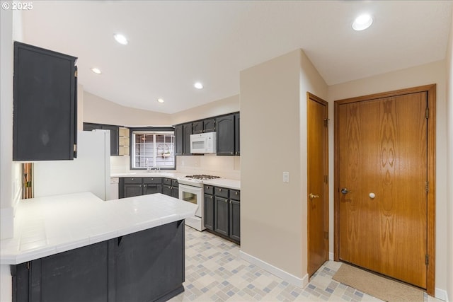 257 SW Nancy Cir, Gresham, OR 97030 - kitchen featuring white appliances, a peninsula, recessed lighting, and vaulted ceiling