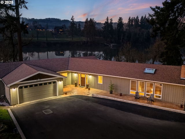 ranch-style home featuring a water view and a garage