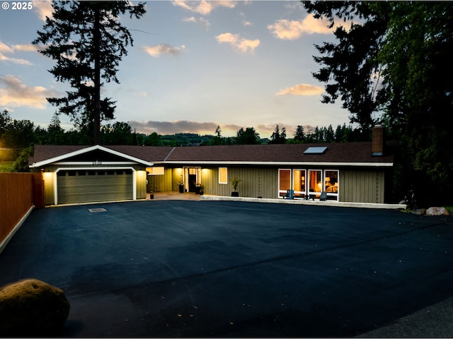 24125 Butteville Rd NE, Aurora, OR 97002 - single story home with an attached garage, a chimney, asphalt driveway, and board and batten siding