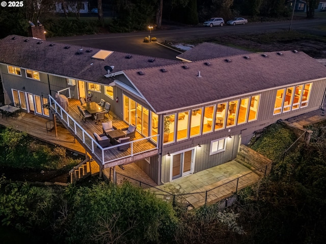 rear view of property featuring a wooden deck and a patio