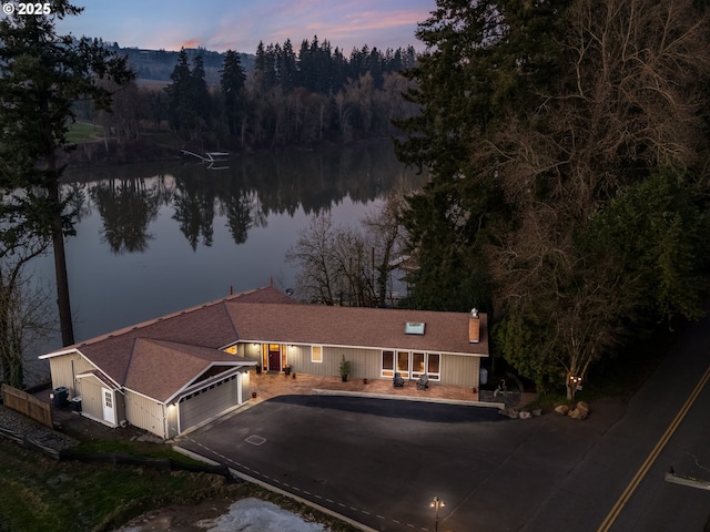 exterior space featuring a garage and a water view