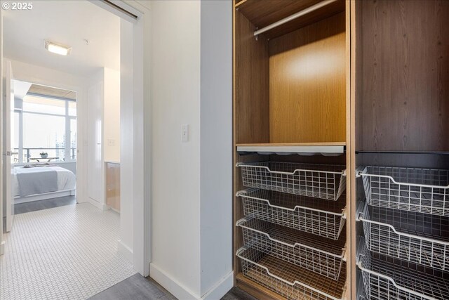 bedroom featuring wood finished floors, baseboards, and a view of city